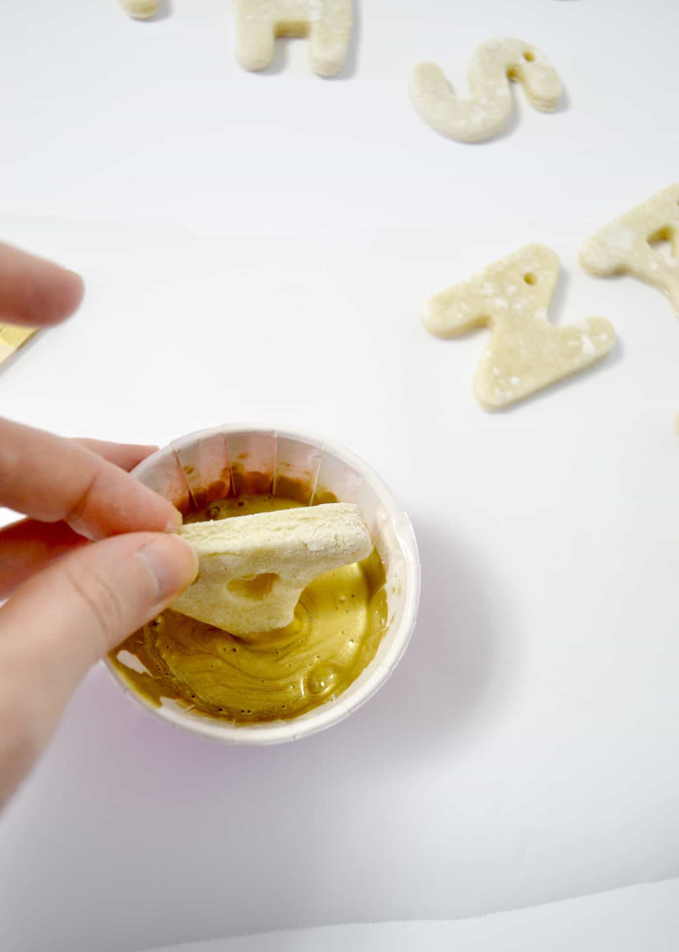 dipping a salt dough ornament in paint